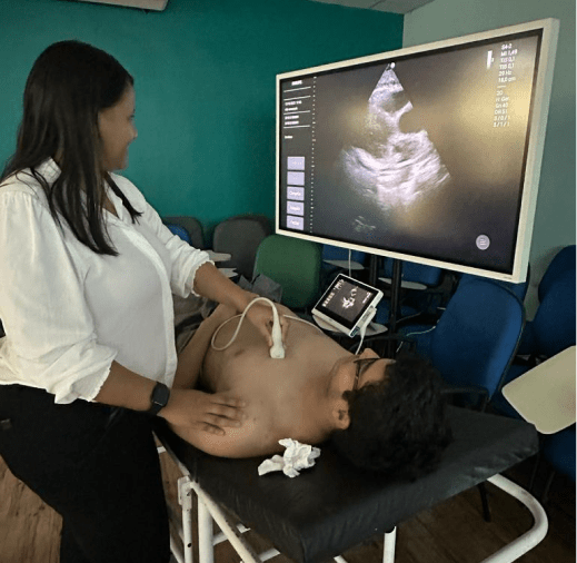 Solo clinician explaining ultrasound results to another student during demonstration in Brazil