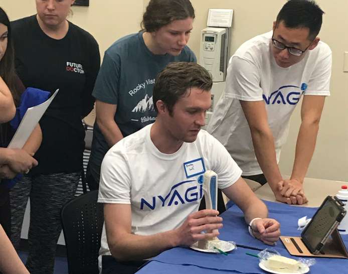 Young healthcare students learning hands-on ultrasound techniques in seminar setting