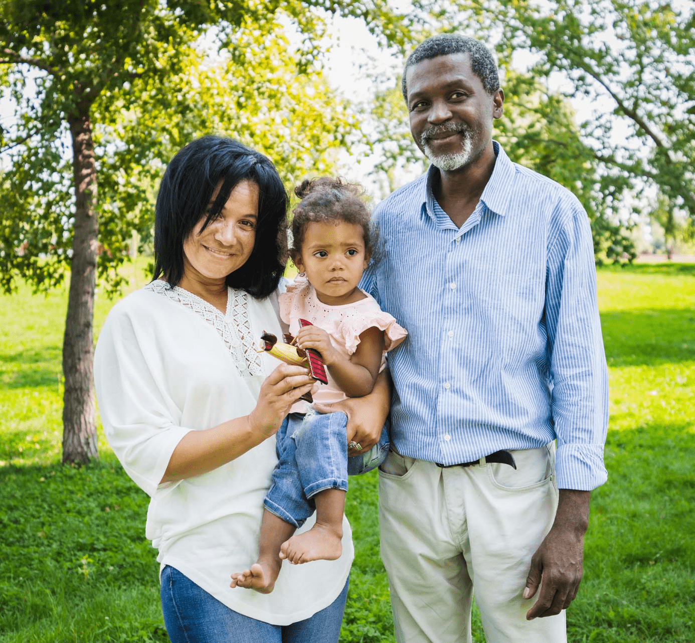 Smiling multi-racial and multi generational family holding a cute child